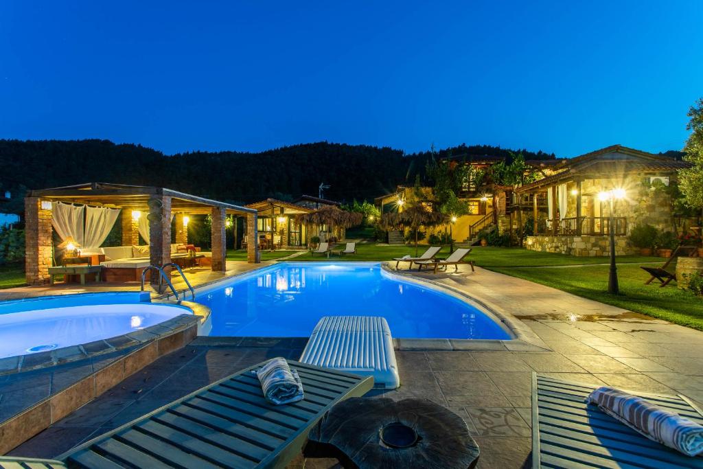 a swimming pool in a backyard at night at Ta Petrina in Vourvourou