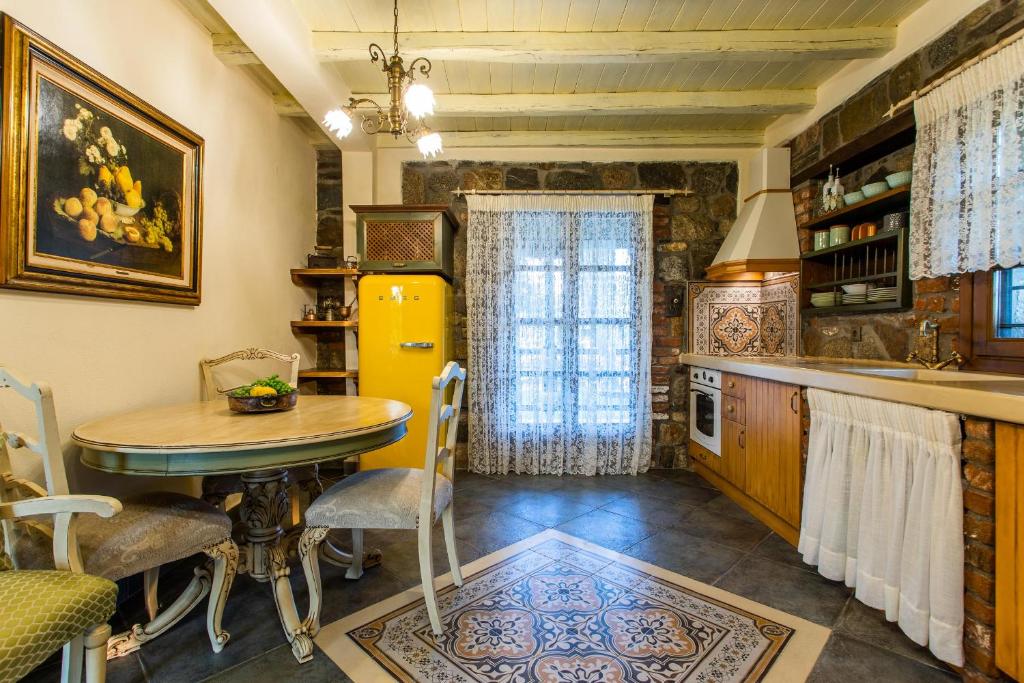 a kitchen with a table and a yellow refrigerator at Ta Petrina in Vourvourou
