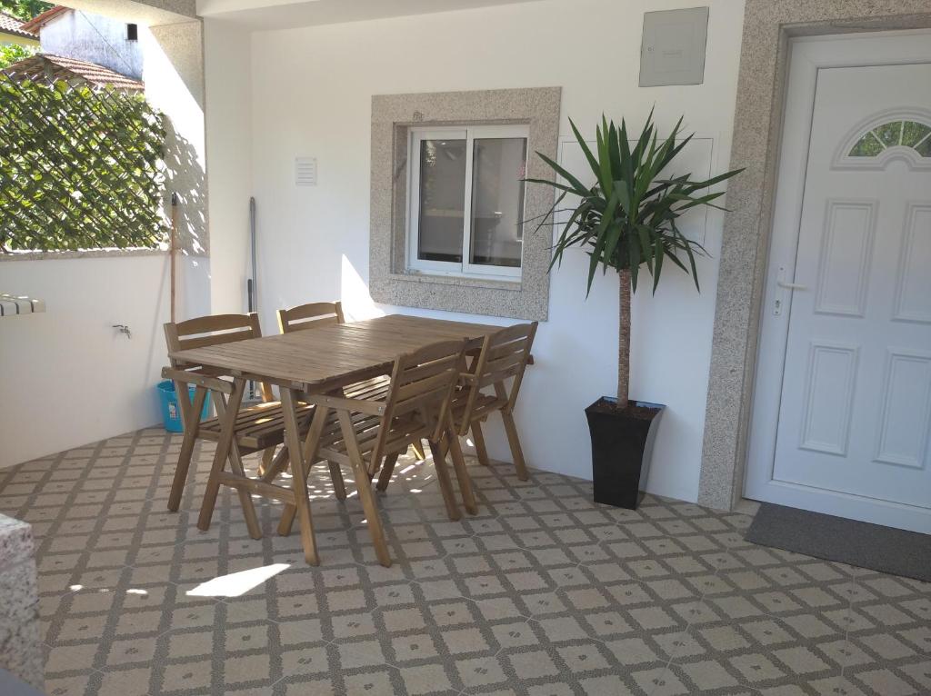einen Holztisch und Stühle auf einer Terrasse mit Topfpflanze in der Unterkunft Casa Morgado in Braga