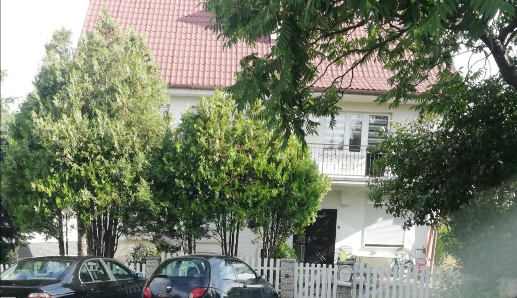 dwa samochody zaparkowane przed białym domem w obiekcie Willa Gorzow-spokojna okolica! w mieście Gorzów Wielkopolski