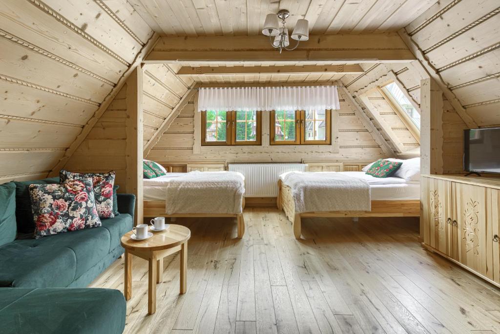 Habitación con 2 camas y sofá en el ático en Willa Hiacynta, en Zakopane
