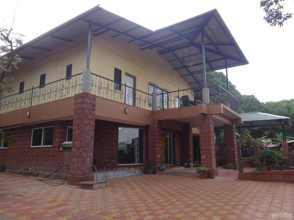 um edifício com uma varanda em cima em Indira Villa - 3BHK Getaway near WaterFalls em Mahabaleshwar