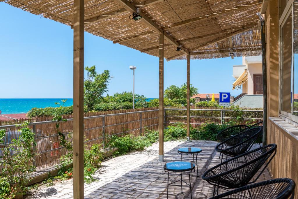 a patio with chairs and tables and a view of the ocean at Hotel Perla in Castiglione della Pescaia