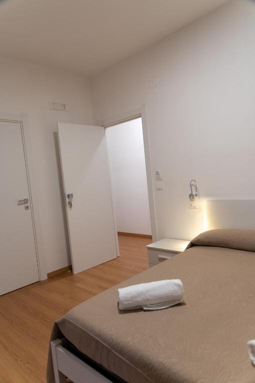 una camera da letto con un letto e un asciugamano bianco di Prestige house a Scalea