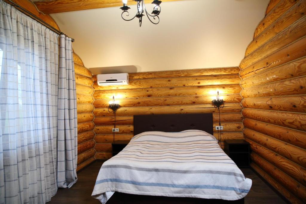コヴロフにあるAtrium Guest Houseのログキャビン内のベッドルーム1室