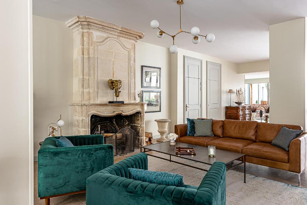 a living room with a couch and a fireplace at Maison des Ambassadeurs in La Rochelle