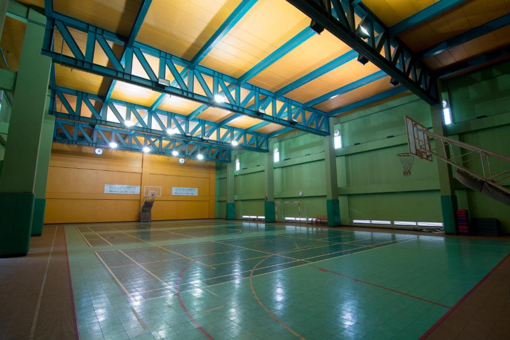 A full indoor basketball court in a high-ceilinged sports hall.