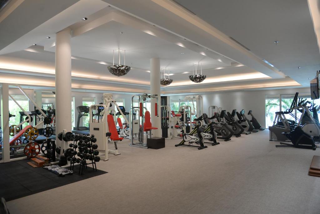 A large, bright fitness room with cardio machines, weights and strength equipment.