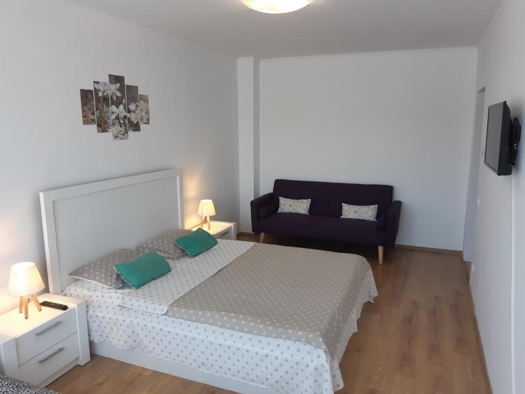 - une chambre avec un lit et une chaise bleue dans l'établissement Maria Terezia Residence, à Sibiu