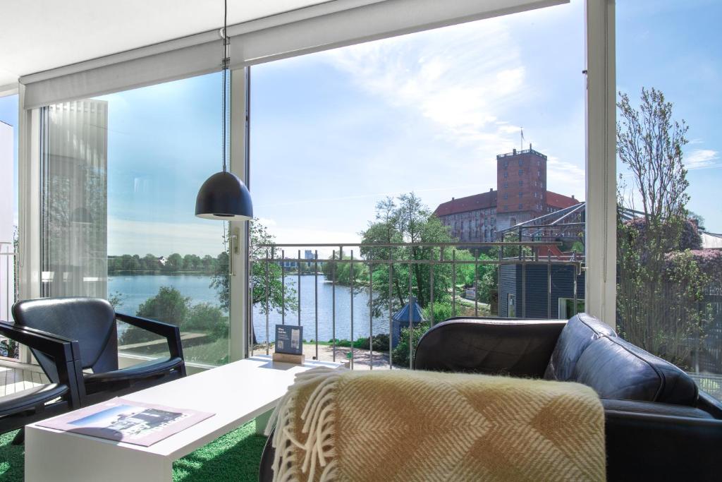 ein Wohnzimmer mit einem großen Fenster mit Blick auf das Wasser in der Unterkunft Kolding Hotel Apartments in Kolding