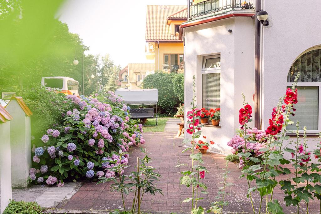 un jardín de flores al lado de un edificio en Dom Gościnny Zielono Mi, en Pobierowo
