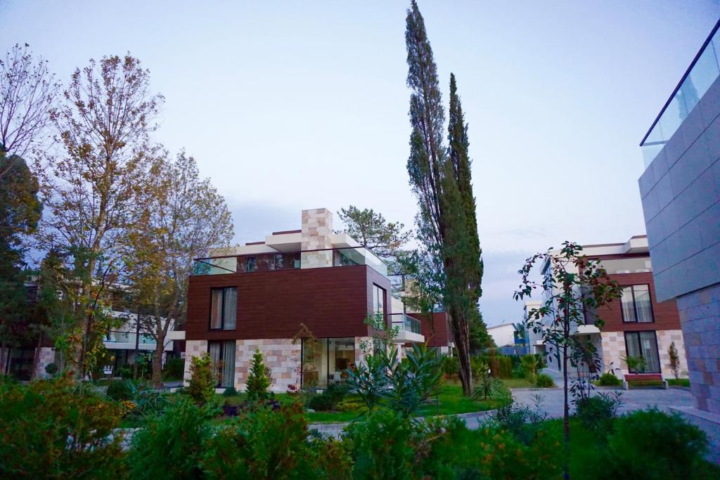 a large red brick building with a tree at Arfa Park-Hotel in Adler