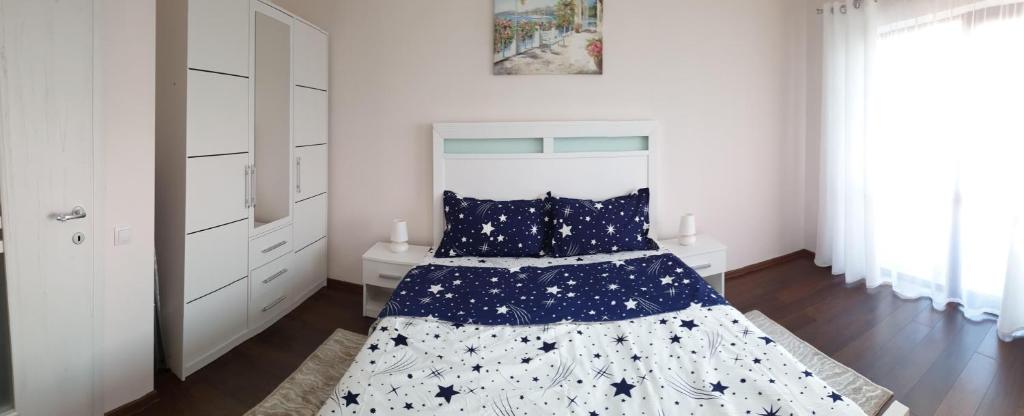 a white bedroom with a bed with stars on it at Eric Apartament’s Suite in Şelimbăr