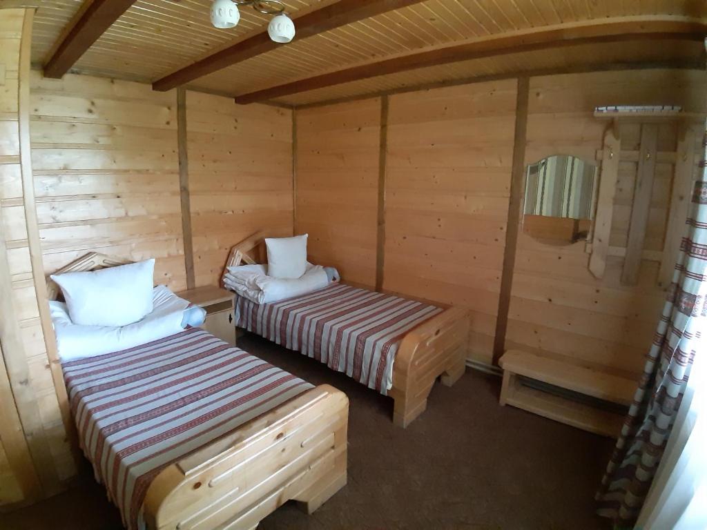 ボロフタにあるСадиба "У Туза"のログキャビン内のベッド2台が備わる部屋です。