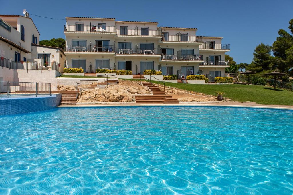 a large swimming pool in front of a house at Apartamentos Torrevella in L'Estartit