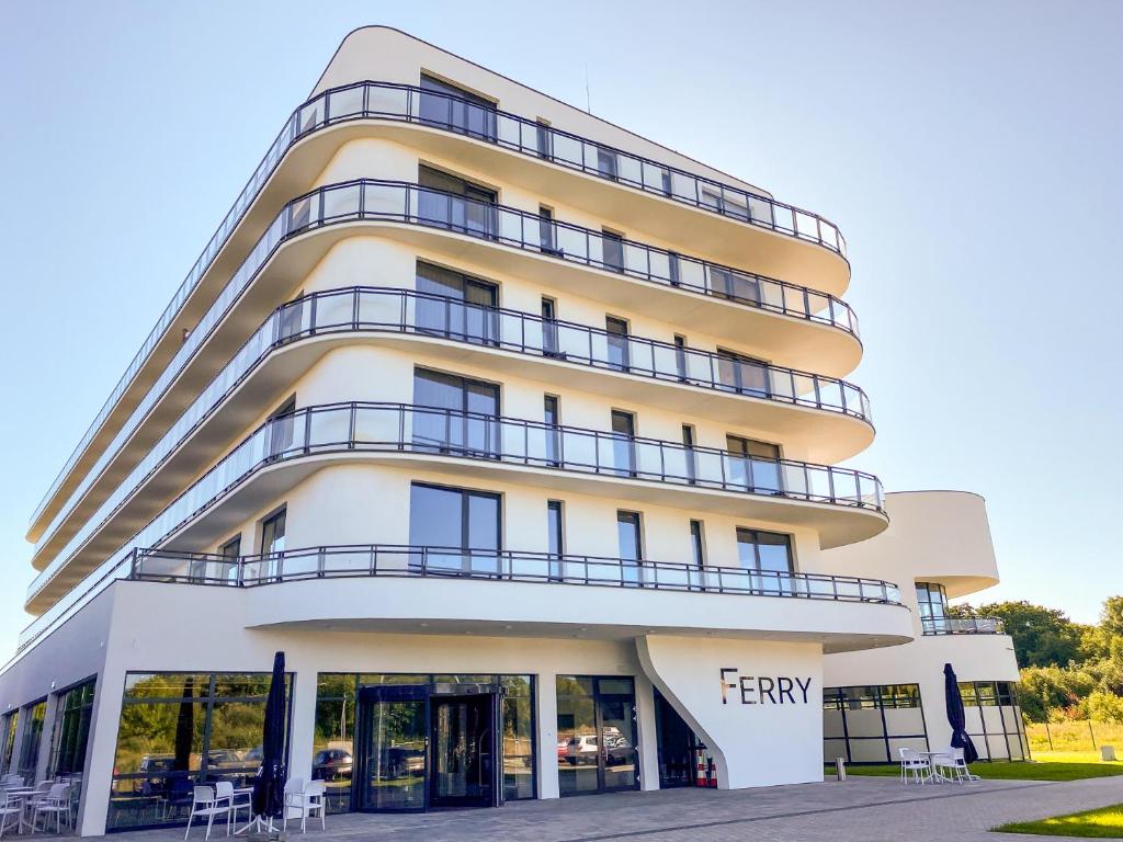 een groot wit gebouw met een bord erop bij Ferry Resort in Mielno