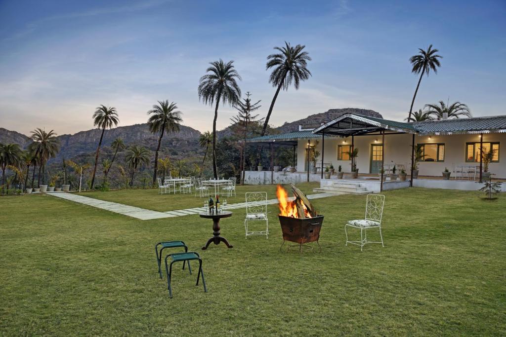 a backyard with a fire pit and chairs and a house at The Mount Bungalow Mount Abu in Mount Ābu