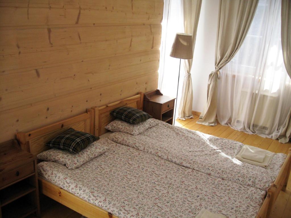 a bedroom with a bed and a wooden wall at Studio 4U Zakopane APARTZAKOP in Zakopane