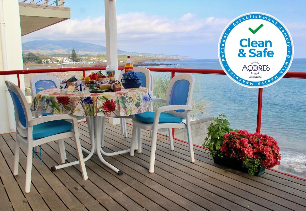 einen Tisch und Stühle auf einer Terrasse mit Meerblick in der Unterkunft Casa do Mar in São Roque