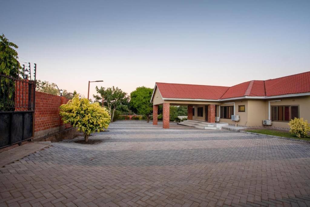 a brick driveway in front of a building at Nzubo Experience in Livingstone
