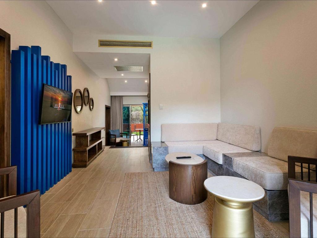 a living room with a couch and a table at Rixos Sungate - The Land of Legends Access in Beldibi