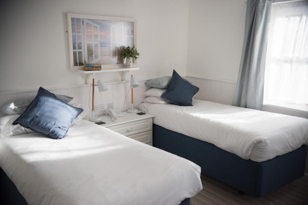 two beds sitting next to each other in a room at Beachlands Hotel in Weston-super-Mare