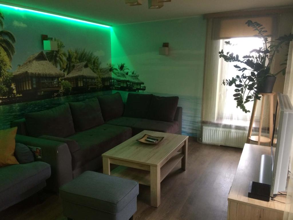 sala de estar con sofá y mesa en Kotedža Tīkli, en Bigauņciems