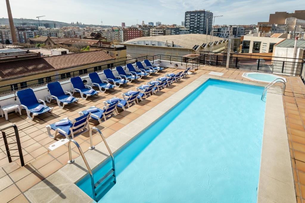 una piscina en la azotea de un edificio con sillas en Sunotel Aston, en Barcelona