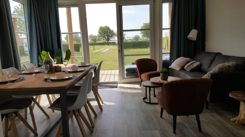 a living room with a table and chairs and a couch at Cassandria Bad - luxe Glamping in Retranchement