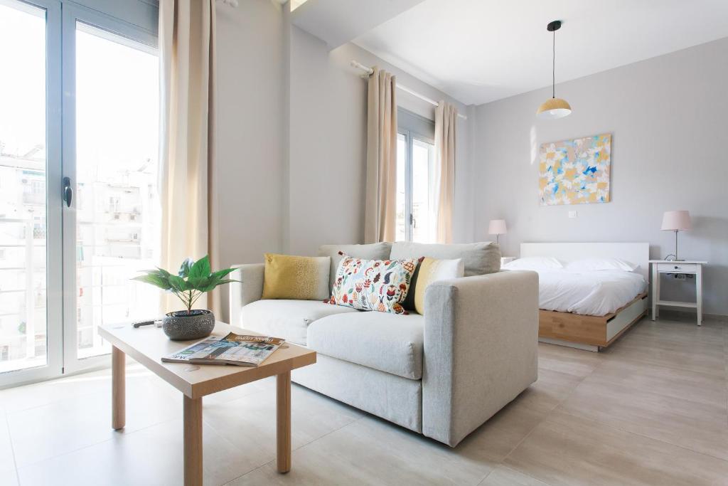 a living room with a couch and a bed at Omnia Pagrati Apartments in Athens