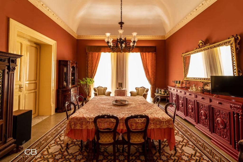una sala da pranzo con tavolo e sedie di Palazzo al Carmine Dimora Storica a Castelvetrano Selinunte