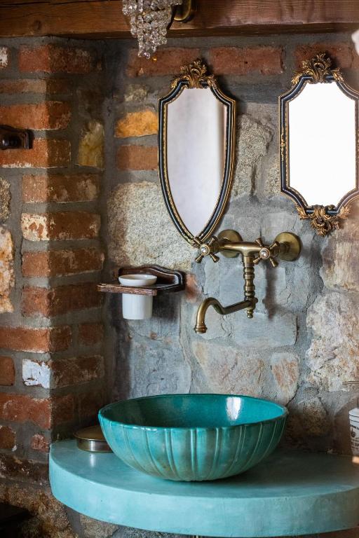 a bathroom with a bowl sink and two mirrors at Ta Petrina in Vourvourou