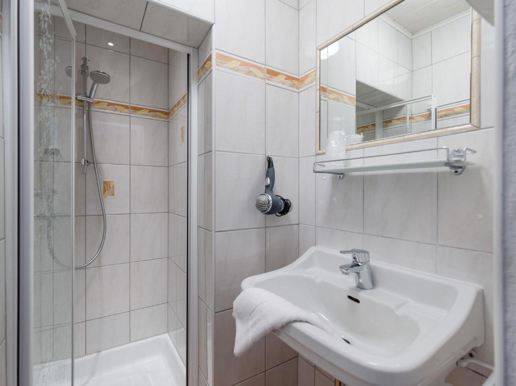 a white bathroom with a sink and a shower at Haus Tirol in Brixen im Thale