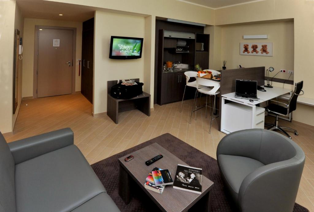 CHC Business Residence في جينوا: غرفة معيشة مع أريكة وطاولة