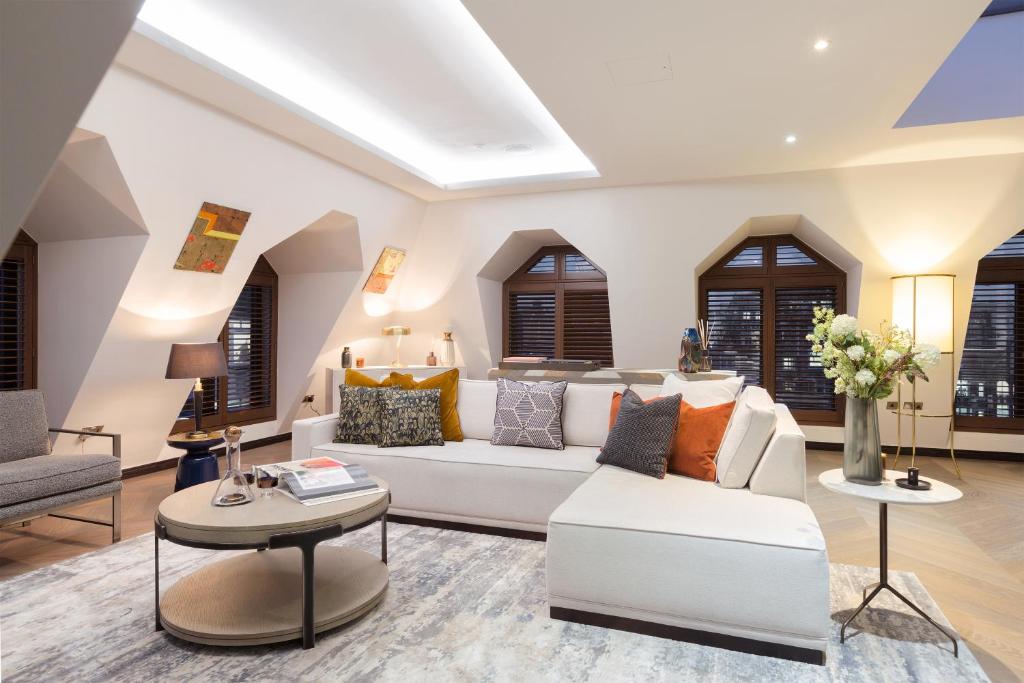 uma sala de estar com um sofá branco e uma mesa em 37GS Residences em Londres