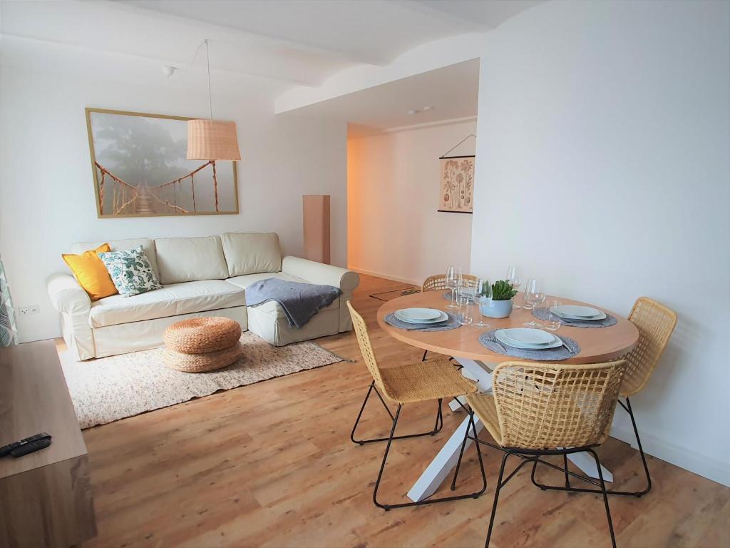 ein Wohnzimmer mit einem Tisch, Stühlen und einem Sofa in der Unterkunft PB Ferienwohnungen - FeWo 1 - Stilvoll eingerichtetes Apartment im Herzen Senftenbergs in Senftenberg