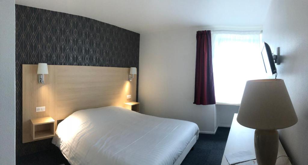 Postel nebo postele na pokoji v ubytování Cit'Hotel LA PYRAMIDE