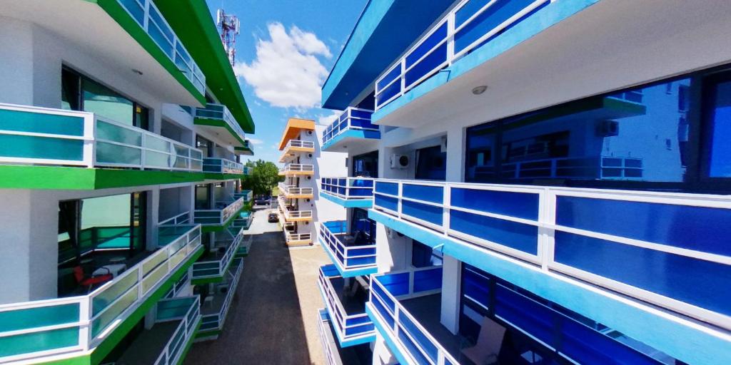 un edificio con balcones azules, mesas y sillas en Magic Costinesti, en Costinesti