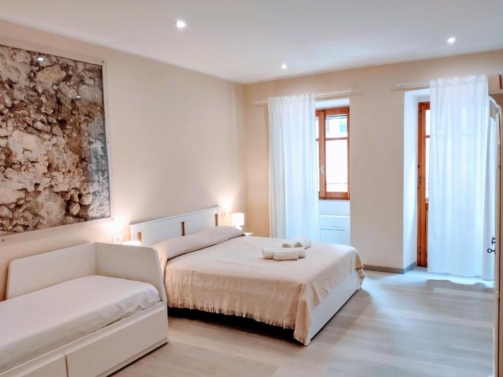 a white bedroom with two beds and a couch at La Dolce Cagliari holiday home in Cagliari