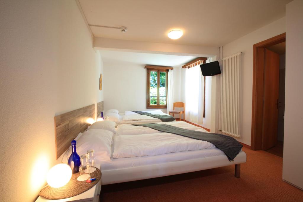 a bedroom with a large white bed and a window at Zappa Lake Lodge in Brusino Arsizio