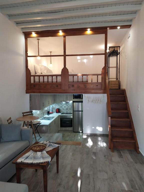 ein Wohnzimmer mit einem Hochbett und einer Küche in der Unterkunft Melikarou houses in Skyros