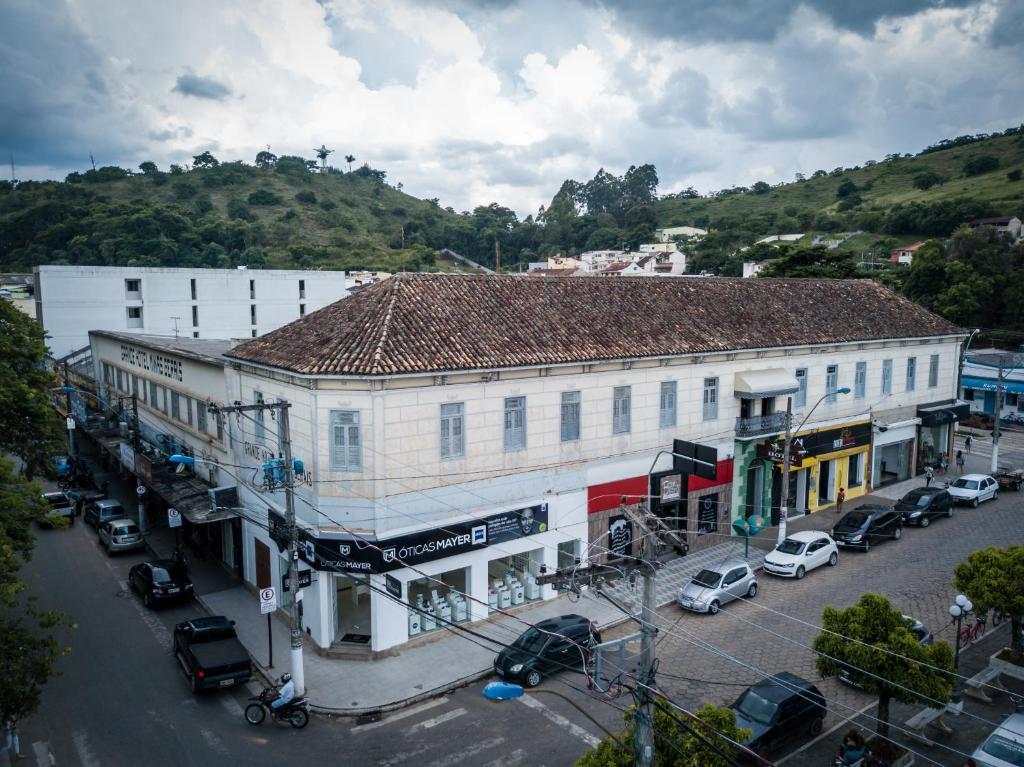 un grand bâtiment blanc avec des voitures garées dans un parking dans l'établissement Grande Hotel Minas Gerais, à Siqueira Campos
