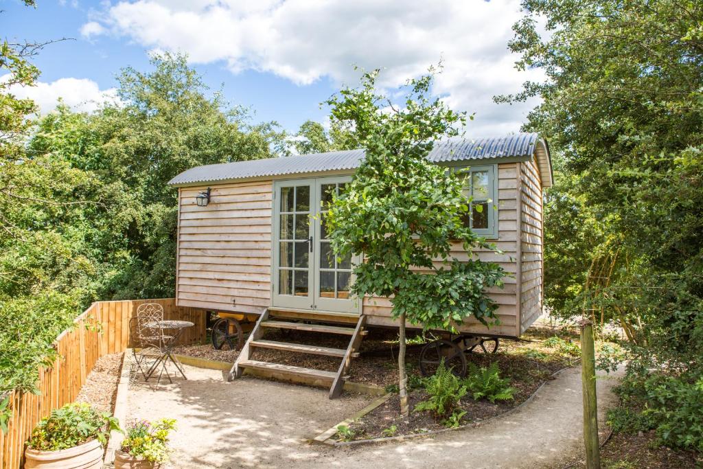 ノッティンガムにあるPerkins luxury shepherd hutsの木の植わる庭の小さな家