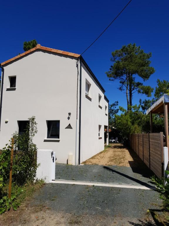 uma casa branca com uma grande garagem em LES EMBRUNS em La Tranche-sur-Mer