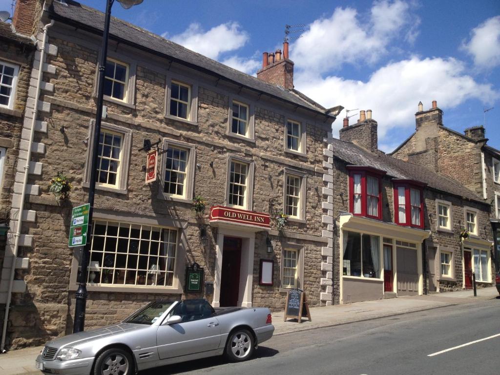 a silver car parked in front of a stone building at The Old Well Inn in Barnard Castle