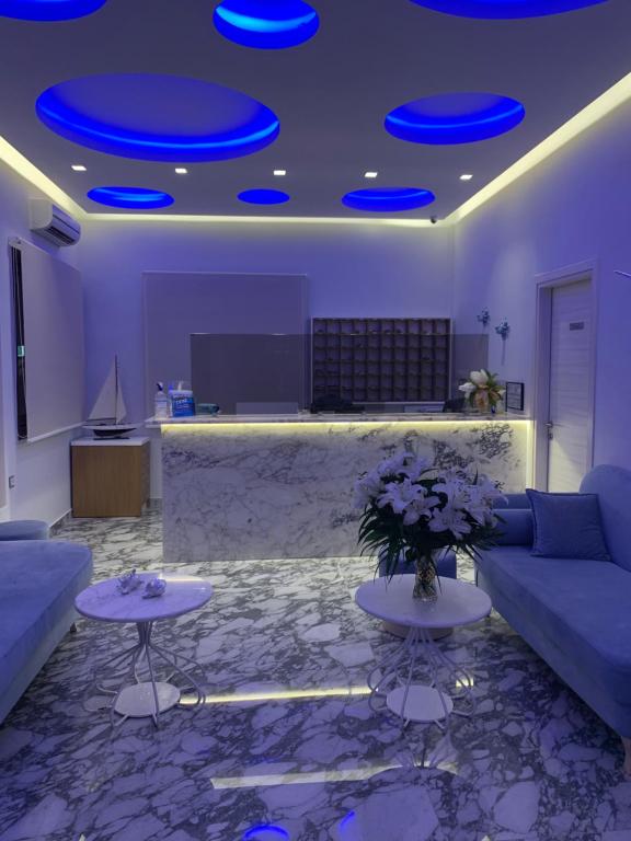 a living room with a couch and tables and blue lights at Vergos Hotel in Vourvourou