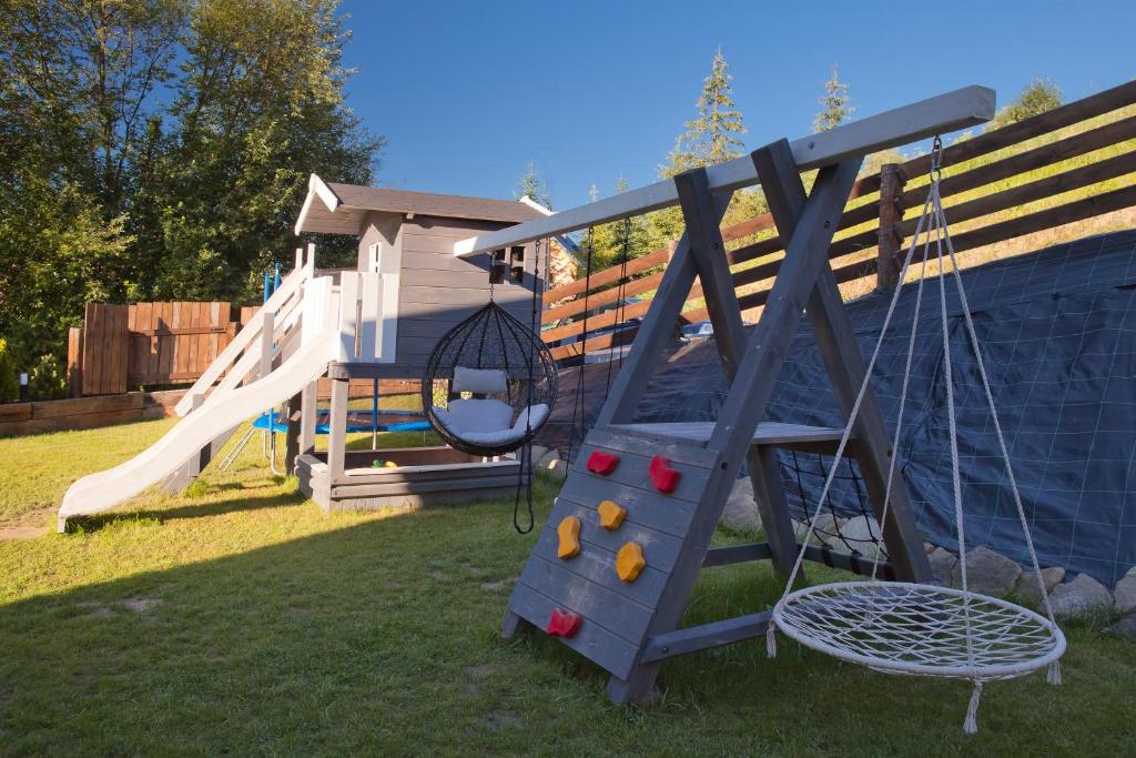 um parque infantil com escorrega e um baloiço em Chata Natura em Muszyna