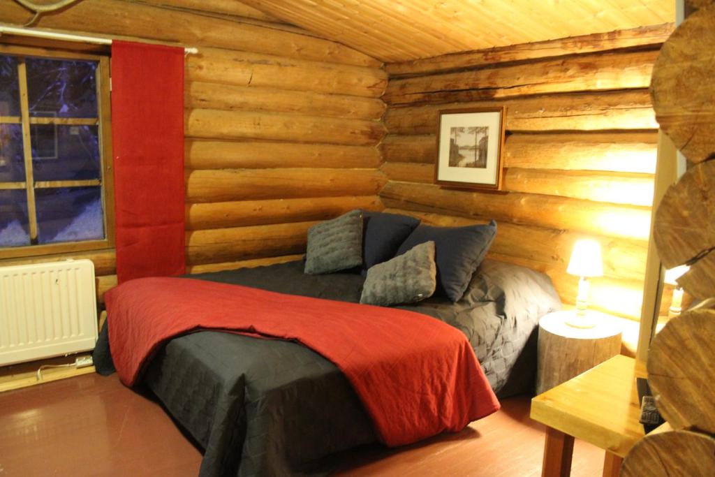 a bedroom with a bed in a log cabin at Cottages RukaTupa in Ruka