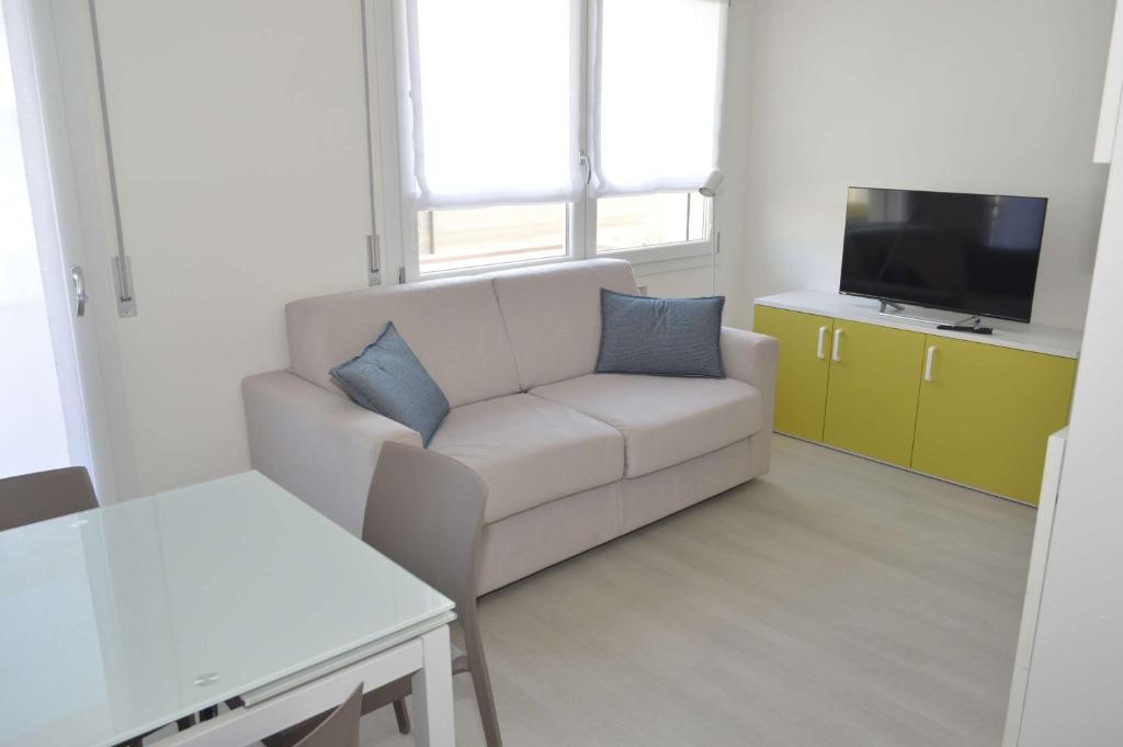 a living room with a couch and a tv at MAR60 Apartments in Caorle