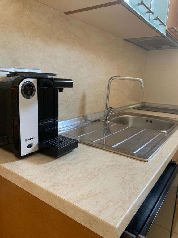 a kitchen counter with a coffee maker and a sink at Vergos Hotel in Vourvourou